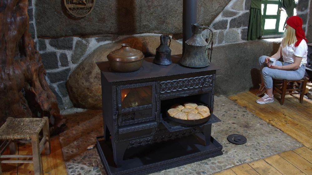 Traditional thick steel wood cook stove used for heating and cooking – rustic design popular in European countryside homes